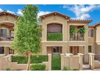 Inviting townhome exterior featuring stucco facade, small balconies, and charming courtyard entrance at 1525 Spiced Wine Ave # 12103, Henderson, NV 89074