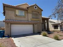 Two-story home featuring a two-car garage, tile roof, and low-maintenance landscaping at 1617 Night Breeze Dr, Las Vegas, NV 89128