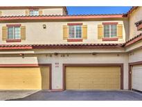View of the garages with tan doors, red trim, and yellow shuttered windows at 5950 Barbosa Dr # 8, North Las Vegas, NV 89031
