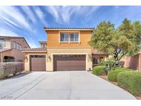 Two-story home with three-car garage, a tile roof, and manicured landscaping enhancing curb appeal at 6659 Alder Flower Ct, North Las Vegas, NV 89084