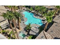 An aerial view of a sparkling community pool with lounge chairs and palm trees at 7119 S Durango Dr # 211, Las Vegas, NV 89113