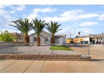 Charming gray single-story home featuring desert landscaping and mature palm trees in the front yard at 113 Elm St, Henderson, NV 89015