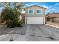 Charming two-story home featuring a spacious driveway, large windows, and a well-maintained front yard at 1704 Kismet Cir, Las Vegas, NV 89108