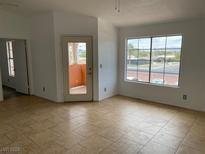 Bright living room featuring tile floors, a large window, and a glass door leading to a balcony at 1830 N Pecos Rd # 252, Las Vegas, NV 89115