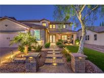 Beautiful two-story home with landscaped front yard, stone walkway, and charming curb appeal at twilight at 7908 Horse Bridle St, Las Vegas, NV 89131
