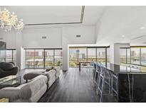 Bright living room featuring dark wood floors, modern furniture, and city views from floor-to-ceiling windows at 3111 Bel Air Dr # 27E, Las Vegas, NV 89109