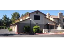 Two-story townhouse featuring a tan exterior with brick accents and a well-maintained landscape at 3232 Dayflower St # 4, Las Vegas, NV 89121