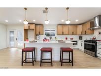 Bright kitchen features white cabinets, large island with seating, modern appliances, and stylish pendant lighting at 4237 E Twain Ave, Las Vegas, NV 89121