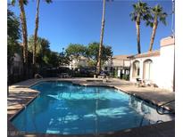 Enjoy the community pool surrounded by palm trees and lounge area at 4555 E Sahara Ave # 226, Las Vegas, NV 89104