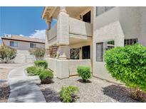 Attractive condominium building with well-maintained landscaping, complemented by a walkway and manicured shrubs at 7952 Diamond Rock Way # 102, Las Vegas, NV 89128