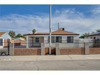 Charming single-story home featuring a secure gated perimeter and a well-maintained front yard at 813 E Bartlett Ave, North Las Vegas, NV 89030