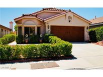 Charming single-story home featuring a well-manicured front yard and a wood-paneled two-car garage at 9355 W Viking Rd, Las Vegas, NV 89147