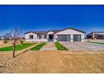 Charming single-story home featuring a modern design with a well-manicured lawn and spacious driveway at 2650 Underbrush Ave, Pahrump, NV 89048