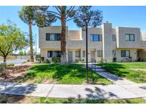 Two story home with a well-manicured lawn and mature trees providing shade at 2696 Matogroso Ln, Las Vegas, NV 89121