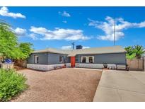 Charming single-story home with a well-manicured yard and an inviting orange front door at 4419 Lorna Pl, Las Vegas, NV 89107