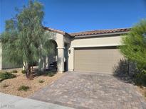 Charming single-story home featuring a desert landscape, brick driveway and a neutral stucco exterior at 4719 N Transcendental St, North Las Vegas, NV 89031
