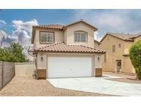 Two-story home featuring a neutral-toned facade, tile roof, two-car garage, and low maintenance landscaping at 5816 Glory Canyon Way, Las Vegas, NV 89142