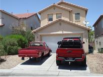 Two-story home featuring a two-car garage with a neutral color palette and low maintenance landscaping at 6772 Oak Mist St, Las Vegas, NV 89139