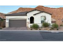 Charming single-story home featuring desert landscaping, a brick driveway, and a two-car garage at 80 Cathedral Wash Pl, Henderson, NV 89011