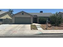 Single story house with a grey roof, a yard with shrubs, and a two car garage in front at 901 Rockaway St, Las Vegas, NV 89145