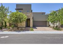 Modern two-story home featuring a stone accent wall and a two-car garage with a landscaped front yard at 1213 Granite Falls Pl, North Las Vegas, NV 89084