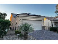 Charming single-story home featuring a two-car garage, solar panels, and desert landscaping at 2704 Willow Wren Dr, North Las Vegas, NV 89084