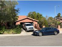 Charming single-story home with a tile roof and two cars parked in the driveway on a sunny day at 3167 El Cedro Cir, Las Vegas, NV 89121