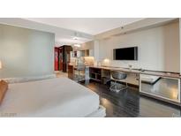 Modern bedroom design with dark wood floors and open concept kitchen, along with a built-in desk at 4381 W Flamingo Rd # 5103, Las Vegas, NV 89103