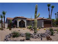 Southwest style home with desert landscaping, including cacti and rock features, plus a brown garage door at 444 Viewmont Dr, Henderson, NV 89015