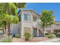 Two story condo featuring a stucco facade, with a small yard and desert landscaping at 5196 Mandalay Springs Dr # 101, Las Vegas, NV 89120