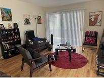 Inviting living room with wood floors, comfortable seating, and bright natural light from sliding glass doors at 5196 Mandalay Springs Dr # 101, Las Vegas, NV 89120