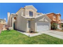 Charming two-story home with a well-maintained lawn, a two car garage and desert landscaping at 6058 Grape Blossom Ave, Las Vegas, NV 89142