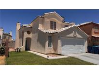 Charming two-story home featuring a tan stucco exterior, tile roof, and an attached two-car garage in a well-maintained neighborhood at 6058 Grape Blossom Ave, Las Vegas, NV 89142