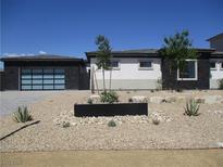Contemporary home showcasing a minimalist landscape design with desert plants and modern architectural elements at 6075 Dapple Gray Rd, Las Vegas, NV 89149