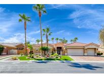 Gorgeous single-story home with a three-car garage, beautiful landscaping and palm trees at 7311 Chaparral Cove Ln, Las Vegas, NV 89131