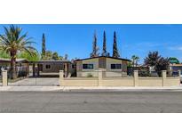 Charming single-story home featuring desert landscaping, and a wrought iron fence at 925 Alan Shepard St, Las Vegas, NV 89145