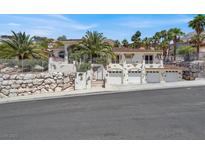 Mediterranean-style home with a 3-car garage, desert landscaping, and a stone retaining wall at 953 Pyrite Ave, Henderson, NV 89011