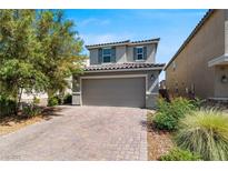 Charming two-story home with a brick driveway and attached two-car garage at 9730 Cluny Ave, Las Vegas, NV 89178