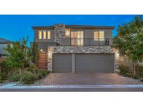 Contemporary two-story home featuring a three-car garage and stone accents, plus a small balcony at 10140 Magnolia Creek St, Las Vegas, NV 89141