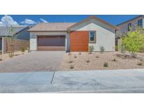 Charming single-story home featuring a brown garage door, a wood panel accent, and desert landscaping at 1021 Golden Summit Dr, Las Vegas, NV 89138