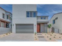 Modern two-story home with a gray garage door and desert landscaping at 10448 Smokey Mariposa, Las Vegas, NV 89166