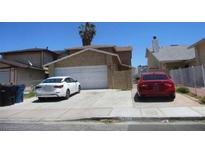 Beige two-story home featuring a two-car garage and driveway parking at 116 Sirnoble St, Las Vegas, NV 89110