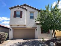 Charming two-story home featuring a neutral stucco facade, brick driveway, and well-maintained landscaping at 147 Augusta Course Ave, Las Vegas, NV 89148