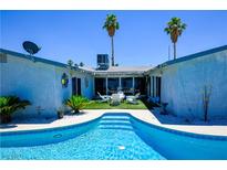 Inviting pool with palm trees and patio area, perfect for outdoor relaxation and entertaining in the backyard at 3030 Liberty Cir, Las Vegas, NV 89121
