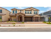 Charming two-story home featuring a stone archway, paver driveway, and a neutral color palette at 453 Winter Dove Ave, Henderson, NV 89011