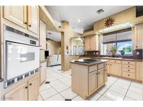 Bright kitchen with island, oven, tile floors, and natural wood cabinetry at 4545 W Agate Ave, Las Vegas, NV 89139