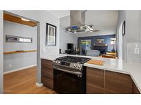 Modern kitchen featuring stainless steel range and hood, quartz countertops, and wood cabinets at 8509 Lansdale Rd, Las Vegas, NV 89123