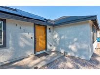 Charming home featuring a bright yellow front door and modern solar panels at 1411 Norman Ave, Las Vegas, NV 89104