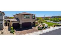 Two-story stucco home with a two-car garage and landscaped front yard in a suburban neighborhood at 7824 Warm Winds St, North Las Vegas, NV 89084