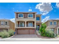 Two-story home featuring stone accents, a balcony, and a three-car garage at 8565 Silver Coast St, Las Vegas, NV 89139